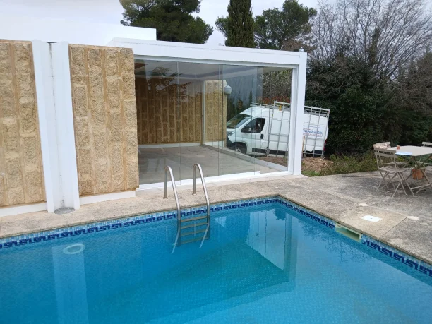 Pergola bioclimatique à lames orientables avec stores intégrés et parois vitrées à Nîmes