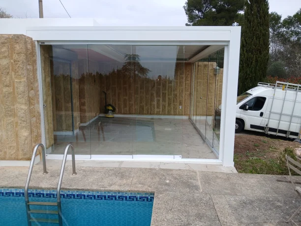 Pergola bioclimatique à lames orientables avec stores intégrés et parois vitrées à Nîmes vue extérieure de face