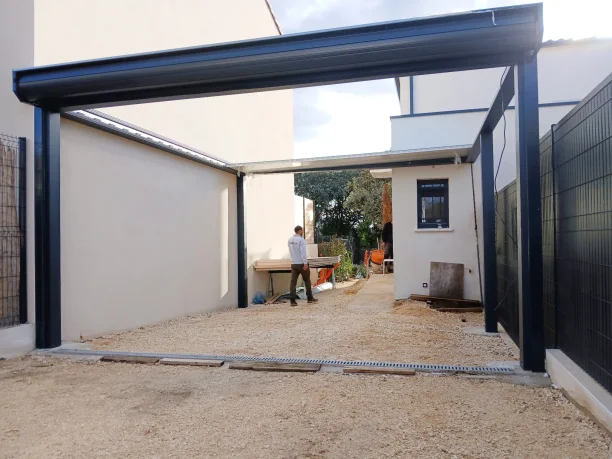 Carport aluminium gris anthracite Akraplast avec porte de garage enroulable à Nîmes pose du toit