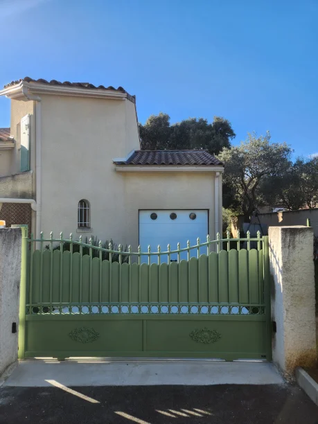 Portail coulissant vert en aluminium modèle traditionnel et porte de garage sectionnelle blanche en aluminium La Toulousaine à Villeneuve-lès-Avignon
