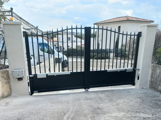 Portail battant noir en aluminium esprit fer forgé avec motorisation à bras articulés dans le Gard