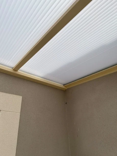 Toiture beige aluminium et polycarbonate Akraplast terrasse Les Angles détail extérieur fixation