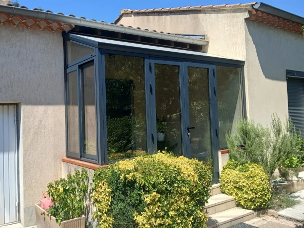 Véranda sas d'entrée gris anthracite aluminium Schüco fabrication TRIOLA Menuiseries Avignon vue extérieure latérale