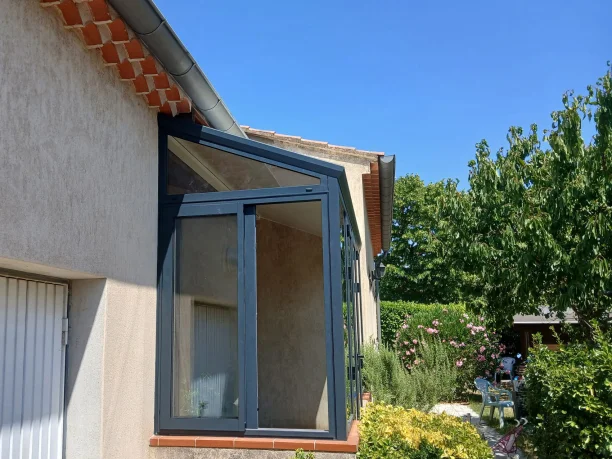 Véranda sas d'entrée gris anthracite aluminium Schüco fabrication TRIOLA Menuiseries Avignon vue extérieure latérale ouvert